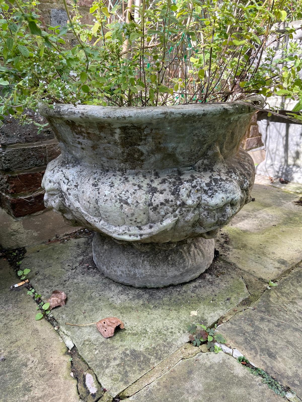 A set of four reconstituted stone circular bulbous garden urns